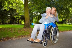 granddaughter embracing her grandmother in wheelchair outdoors