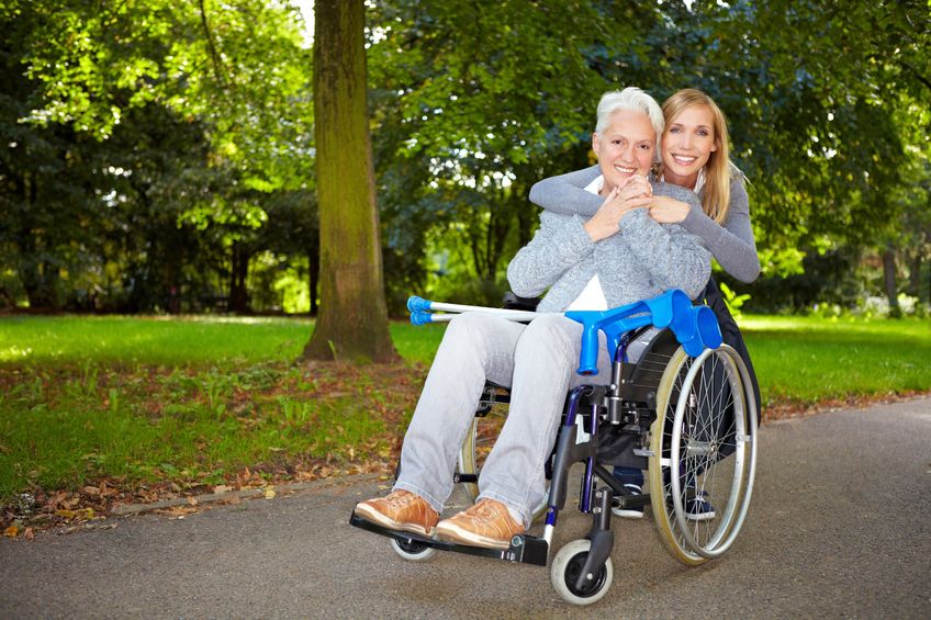8287050 - granddaughter embracing her grandmother in wheelchair outdoors